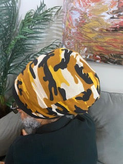 Man wearing a yellow camouflage stretch hat. The hat has a round flat top and available in different lengths from 10" to 20".
