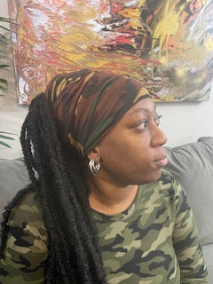 Woman wearing a dark camouflage turban with an open top. Available in different lengths from 10" to 18".