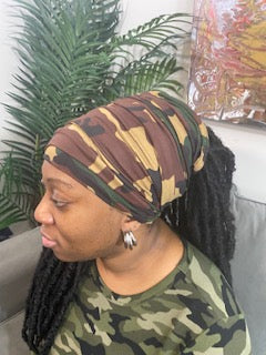 Left View - Woman wearing a dark camouflage turban with an open top. Available in different lengths from 10" to 18".