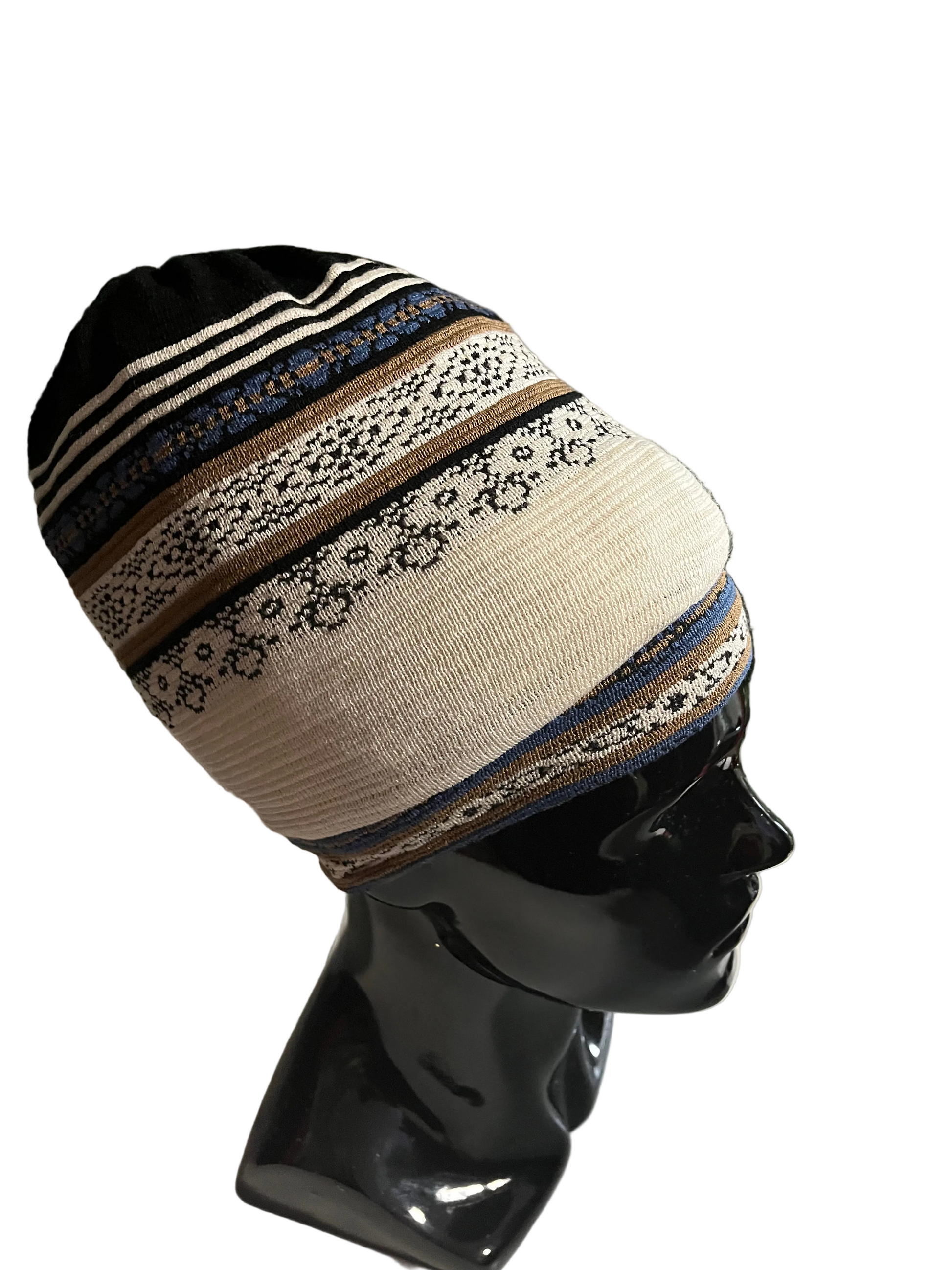A stretch fabric hat displayed on a mannequin head, featuring geometric patterns with colors royal blue, cream, black, and coffee, and a black band with a striped design.